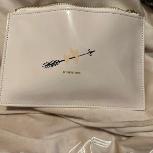 Case is 5 1/2 x 8 inches. Light blush pink with gold zipper and pull tag.